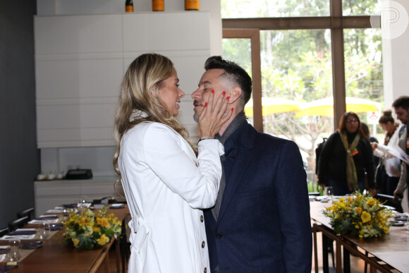 Adriane Galisteu recebe o carinho do marido, Alexandre Iódice, no lançamento do seu novo programa, na Band News
