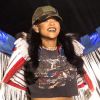 No palco, Rihanna combina a cor do batom com a da camiseta