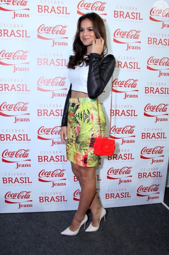 Bruna Marquezine usa top cropped branco com mangas pretas e saia colorida antes de desfilar pela Coca-Cola. A atriz desfilou uma clutch Lego da Chanel, que custa cerca de R$ 30 mil