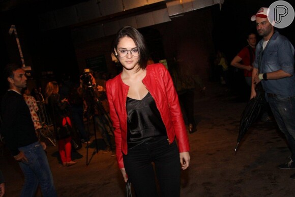 Isabelle Drummond chegou ao Fashion Rio com blusa e calça pretas. Por cima, uma jaqueta vermelha