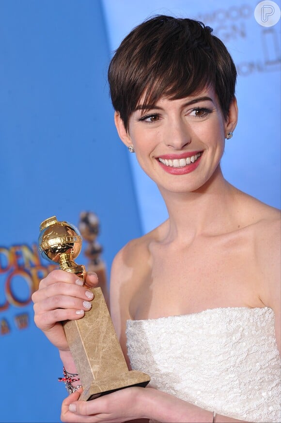 Anne Hathaway segurando o prêmio de Melhor Atriz Coadjuvante por sua atuação em 'Les Miserables', na cerimômia do Globo de Ouro em janeiro de 2013