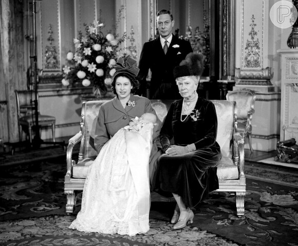 A rainha Elizabeth II segurando seu filho, o príncipe Charles, após sua cerimônia de batismo no Palácio de Buckingham, em 15 de dezembro de 1948