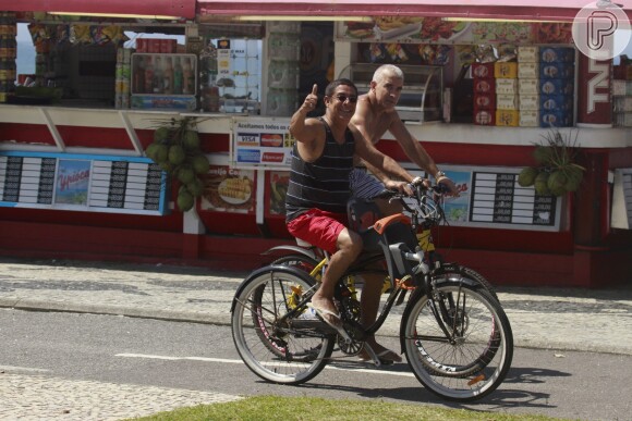 Zeca Pagodinho acena para fotógrafo enquanto pedala na orla