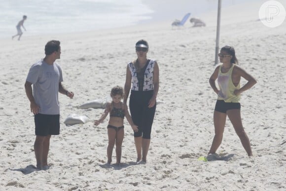 Flávia Alessandra na praia com as filhas e seu personal trainer: exercício em família