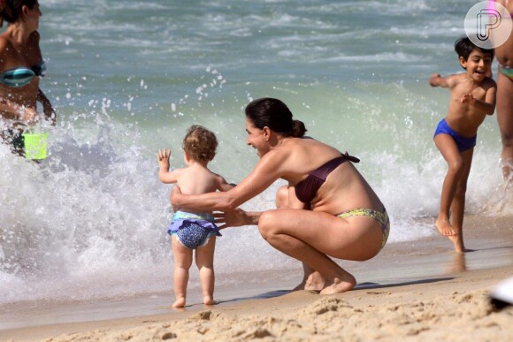 Totia Meirelles brinca com a neta na praia