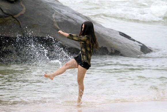 A atriz brinca com a água do mar