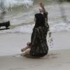 A atriz brinca com a areia da praia