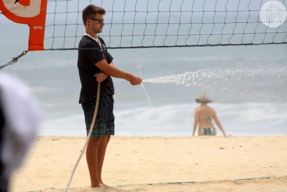 Rodrigo usou uma mangueira para molhar e refrescar a areia da praia