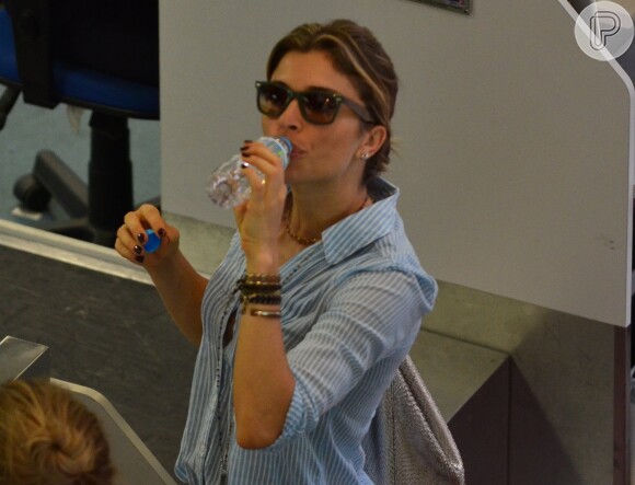 Grazi Massafera bebe água durante o check-in