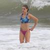 Fernanda Lima ajeita o biquíni antes de sair do mar