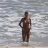 Thayla Ayala dá um mergulho no mar e acena para o fotógrafo