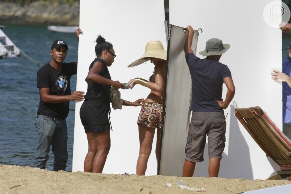 Assistente de produção ajuda Rihanna durante o ensaio em Ilha Grande