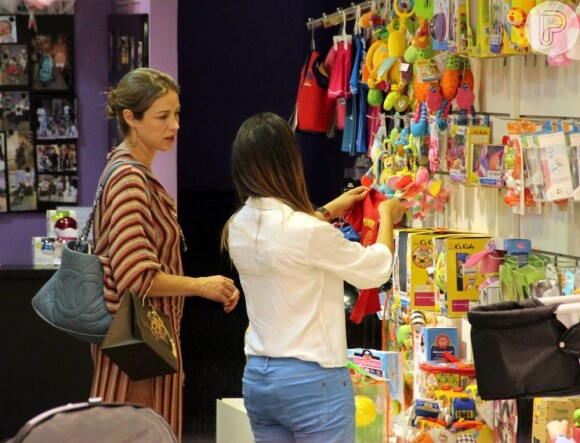 A vendedora mostra os brinquedos para Luana