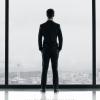 Jamie Dornan aparece sozinho, vestindo seu famoso terno cinza, no primeiro pôster divulgado de '50 Tons de Cinza'