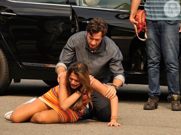 Luiza (Bruna Marquezine) chora, com dor no ombro e Laerte (Gabriel Braga Nunes) a ajuda a se levantar, e cena da novela 'Em Família'