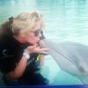 Com Vittorio no colo, Adriane beija golfinho em parque aquático