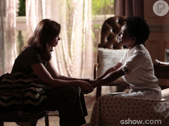 Helena (Julia Lemmertz) ajuda Neidinha (Elina de Souza) a guardar seu segredo na novela 'Em Família'