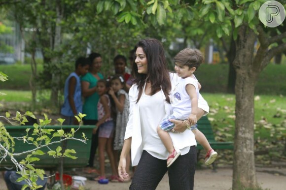 Juliana Paes, sorridente, com o filho no colo