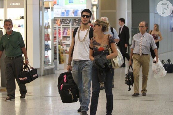 Tammy Di Calafiori e Emiliano D'Ávila foram vistos circulando pelo aeroporto Santos Dumont, no Rio, bastante sorridentes e com roupas confortáveis para entrar no avião. Para dar um detalhe à roupa, o ator usou um colar