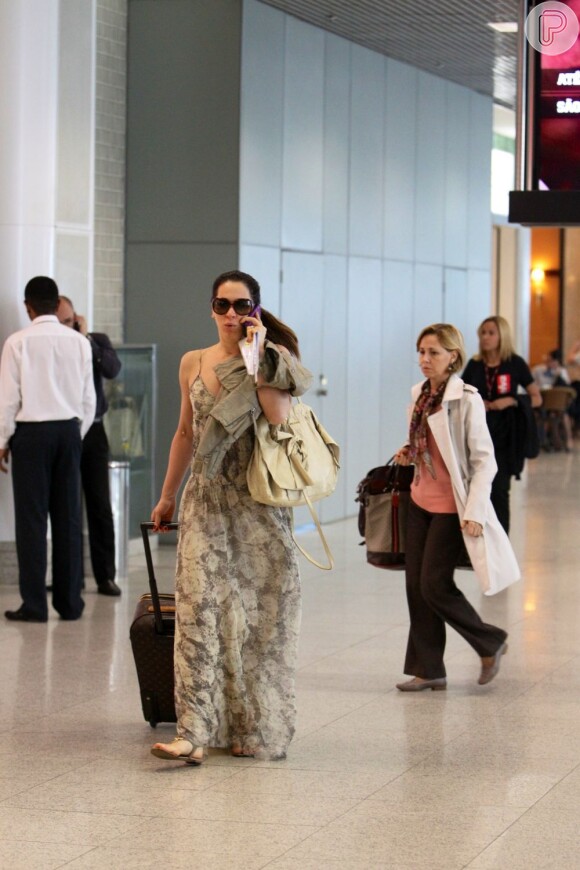 Claudia Raia escolheu um vestido longo, bem confortável, com estampa de cobra para entrar mais uma vez num avião. Com sua mala de mão da grife Louis Vuitton, a atriz foi vista andando pelo Santos Dumont, no Rio, no dia 23 de novembro de 2012