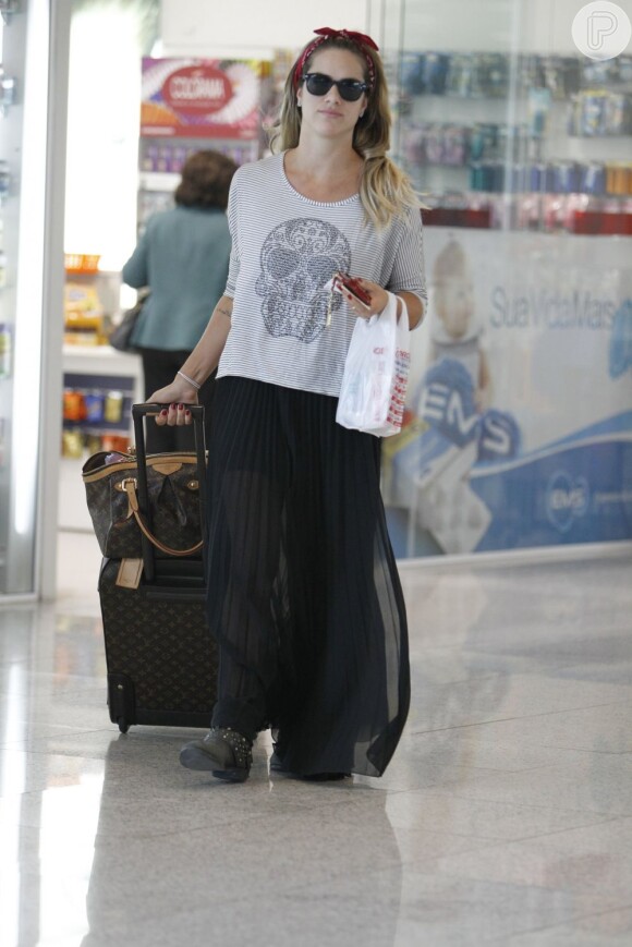 Giovanna Ewbank foi fotografada no dia 23 de agosto no aeroporto Santos Dumont com bolsa e mala de mão da grife Louis Vuitton. A atriz escolheu uma saia longa transparente e uma camiseta para usar no avião