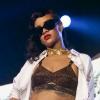Rihanna faz show com um conjuntinho branco e um sutiã de oncinha