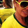 Adriane Galisteu usa camisa da Seleção Brasileira personalizada com a frase 'Mãe do Vittorio'. A apresentadora também escolhe óculos na cor amarela