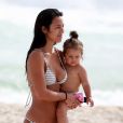 Yanna Lavigne caminha pela praia com a filha, Madalena, no colo