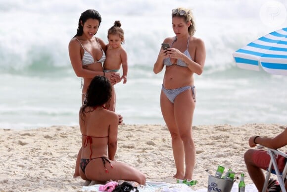 Yanna Lavigne, com Madalena no colo, conversa com amigas depois de entrar no mar