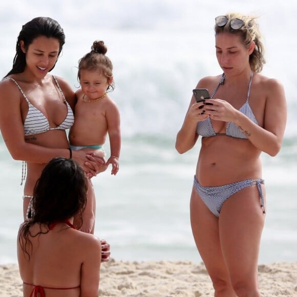 Yanna Lavigne, com Madalena no colo, conversa com amigas depois de entrar no mar