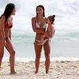 Yanna Lavigne caminha na areia com a filha, Madalena, no colo