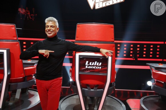 Lulu Santos posa ao lado de sua cadeira no 'The Voice Brasil'