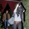 Scarlett Johansson esconde o rosto dos paparazzi ao sair de restaurante com o ator Sean Penn, ao fundo, em 2011