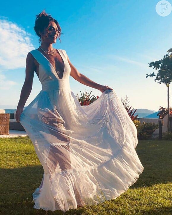 O vestido longo branco com decote mega profundo babados na barra foi a escolha de Juliana Paes para o look do Réveillon 2019