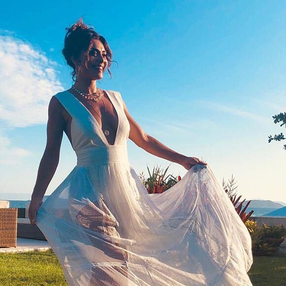 O vestido longo branco com decote mega profundo babados na barra foi a escolha de Juliana Paes para o look do Réveillon 2019