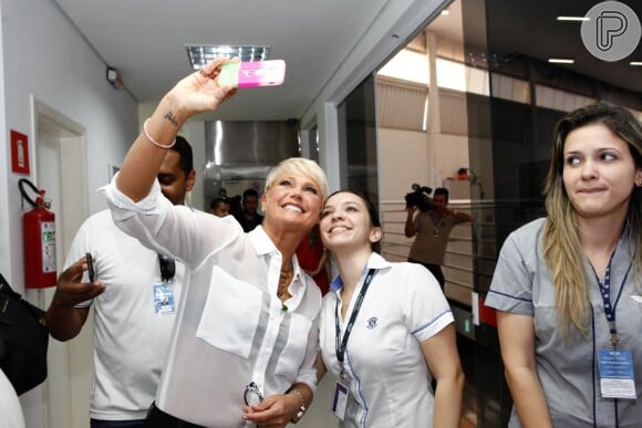 Sempre atenciosa, Xuxa faz selfie com os funcionários do aeroporto