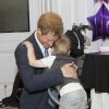 Príncipe Harry encanta crianças e ganha abraço de menino durante visita à instituição London Hilton, em Londres, nesta segunda-feira, 22 de setembro de 2014
