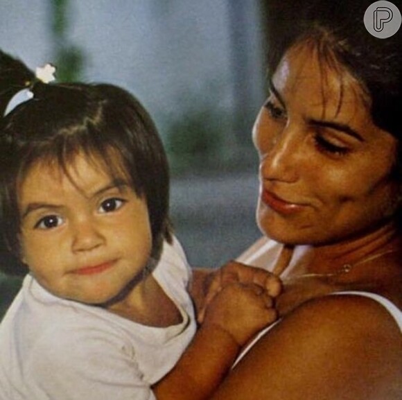 Cleo ainda pequena no colo da mãe, Gloria Pires: cabelos lisos, franja e uma bochechinha que encantava