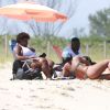 Anitta conversa com amigos em dia de folga na praia da Barra da Tijuca