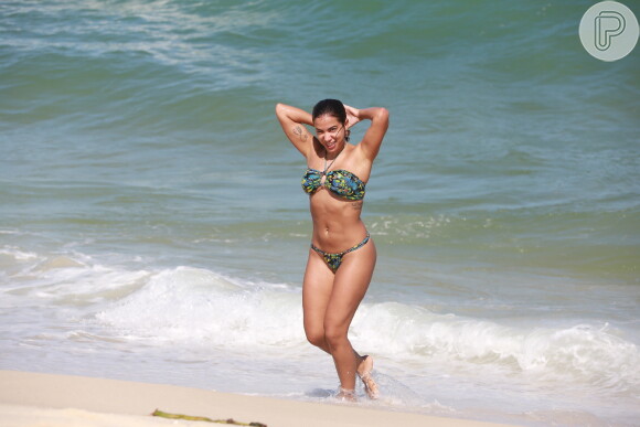 Anitta arruma cabelo ao sair do mar da praia da Barra da Tijuca
