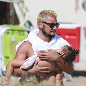 Bruno Gissoni segura a filha no colo enquanto a menina dorme tranquilamente