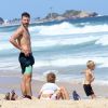Rodrigo Hilbert observa os filhos, João e Francisco, brincarem em praia no Rio de Janeiro