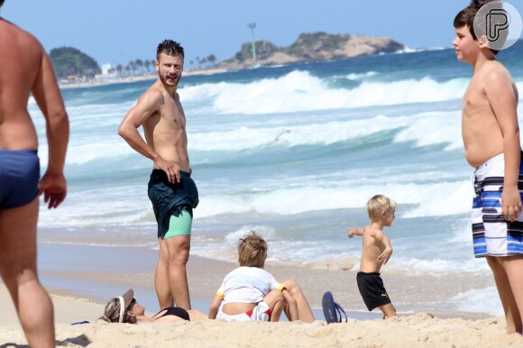 Rodrigo Hilbert observa os filhos, João e Francisco, brincarem em praia no Rio de Janeiro