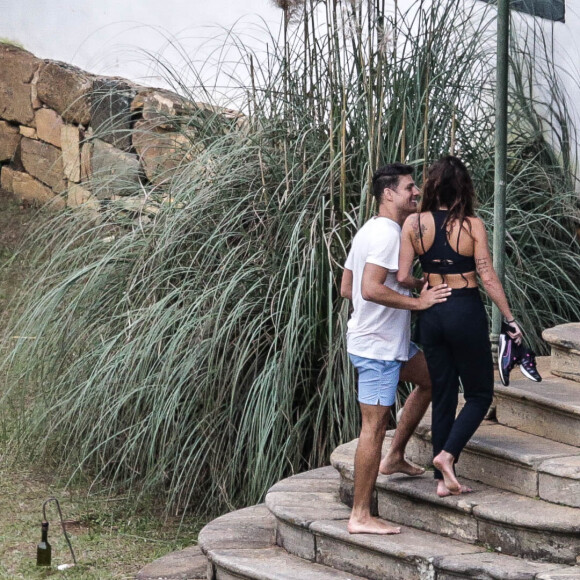 Cauã Reymond sorri com Mariana Goldfarb ao subir as escadas de hotel