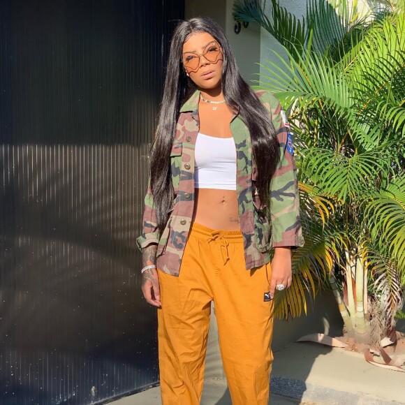 Ludmilla usou calça jogging, top cropped branco, jaqueta com print do militarismo, óculos com lente amarela e tênis da grife Gucci