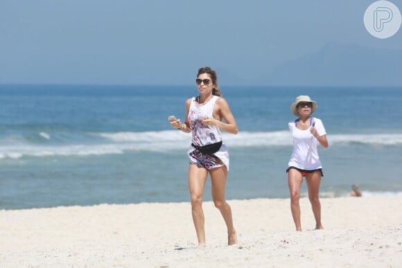 Antes de pegar sol, Grazi Massafera se exercitou na areia ao lado da amiga Anna Lima