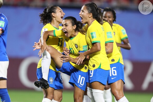 Marta vibra ao fazer o gol de pênalti acompanhada das demais jogadoras da seleção