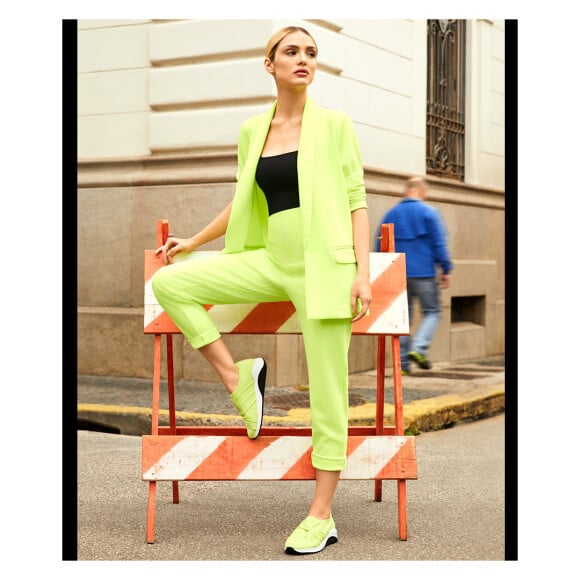 Na campanha de moda, Isabelle Drummond posa com conjuntinho de alfaiataria neon e tênis moderno de mesma cor