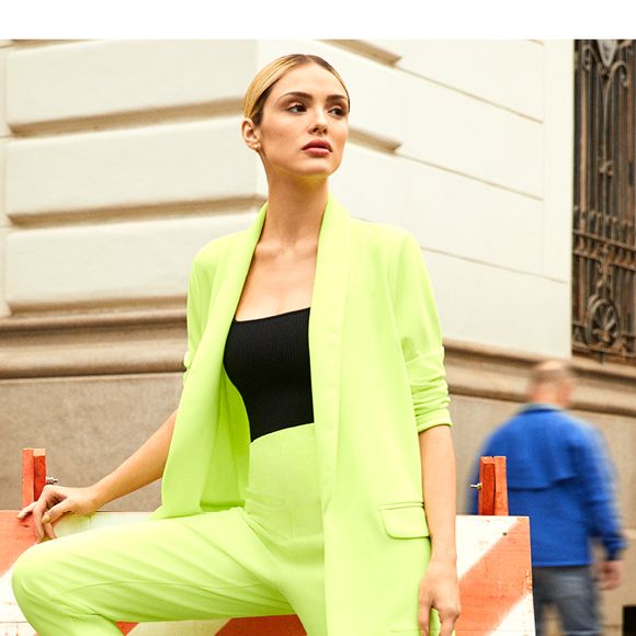 Na campanha de moda, Isabelle Drummond posa com conjuntinho de alfaiataria neon e tênis moderno de mesma cor