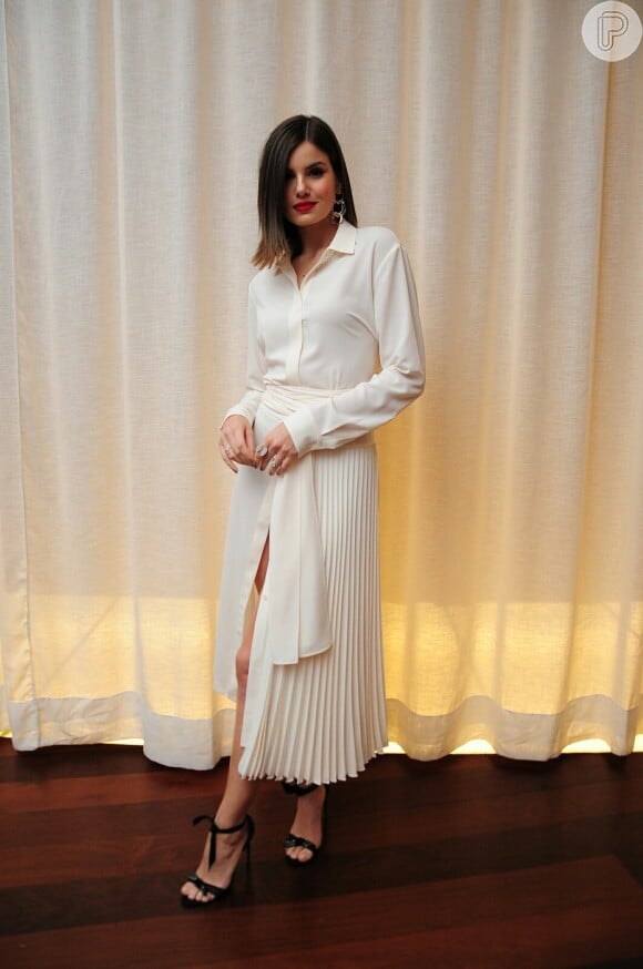 O vestido longo branco e plissado usado por Camila Queiroz no coquetel da GQ Brasil é da grife Hugo Boss e custa R$3.540